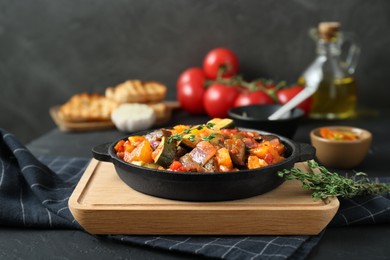 Photo of Dish with tasty ratatouille on black table