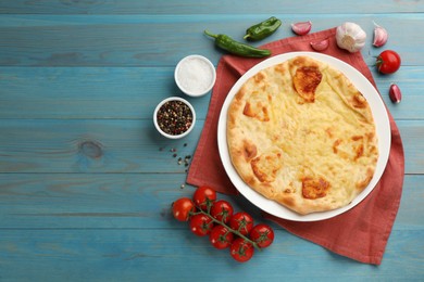 Photo of Delicious khachapuri with cheese on light blue wooden table, flat lay. Space for text