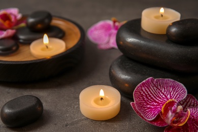 Beautiful composition with candles and spa stones on table