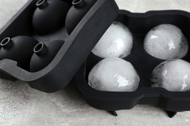 Photo of Frozen ice balls in mold on grey table, closeup