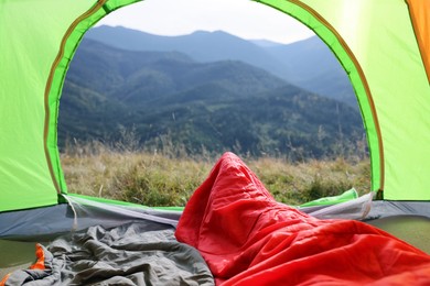Photo of Sleeping bags in camping tent outdoors, view from inside