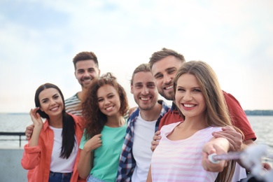 Photo of Happy young people taking selfie outdoors on sunny day