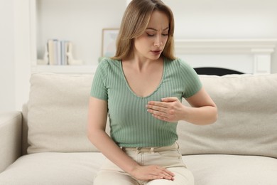 Photo of Mammology. Young woman doing breast self-examination at home