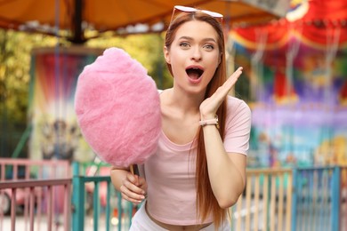 Photo of Excited woman with cotton candy at funfair