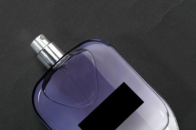 Photo of Luxury men`s perfume in bottle on black background, top view