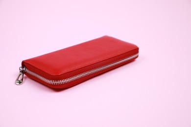 Photo of Stylish red leather purse on pink background, space for text