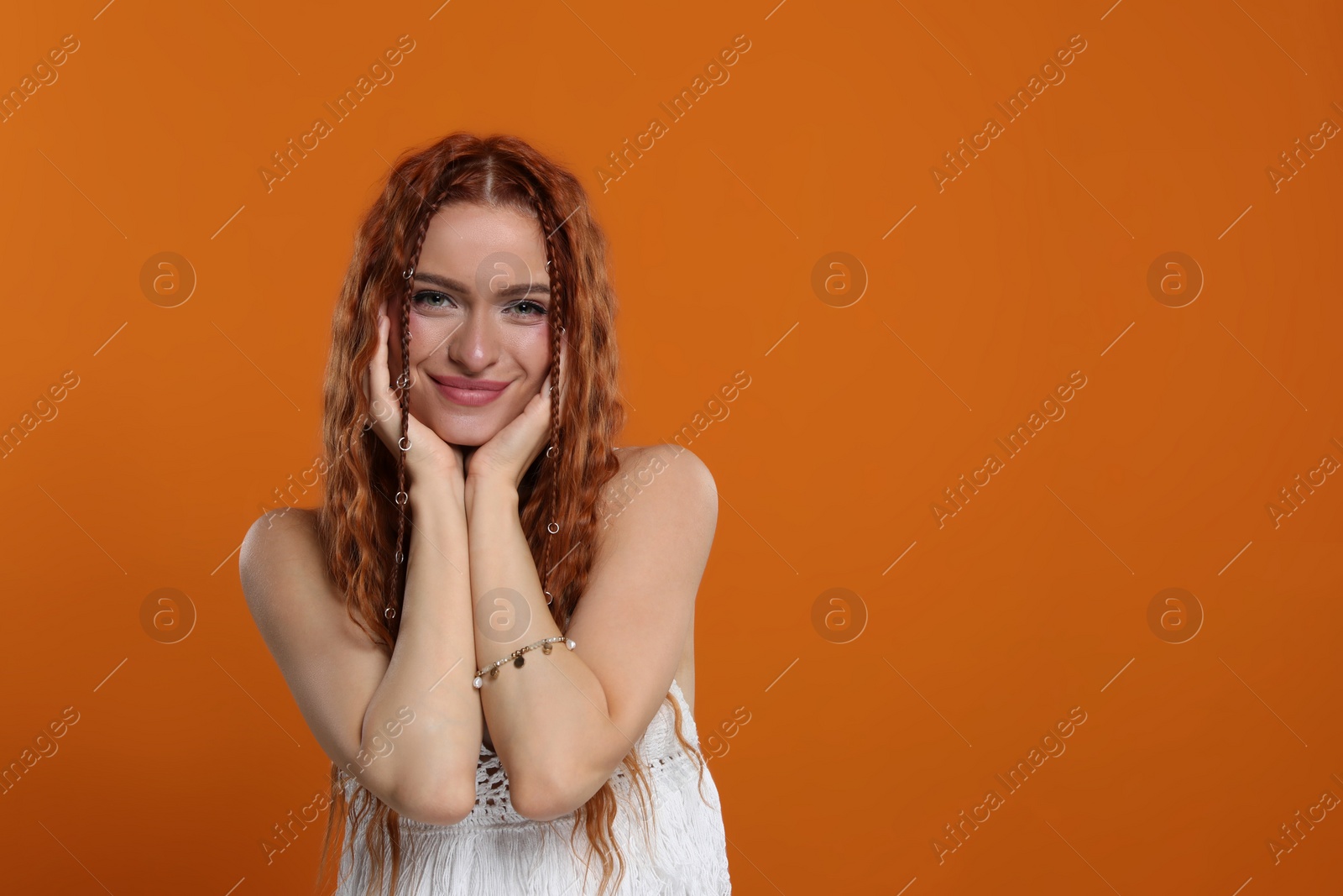 Photo of Beautiful young hippie woman on orange background, space for text