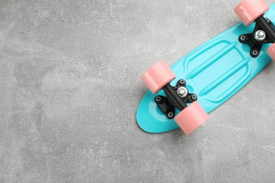 Photo of Turquoise skateboard on grey stone background, top view. Space for text