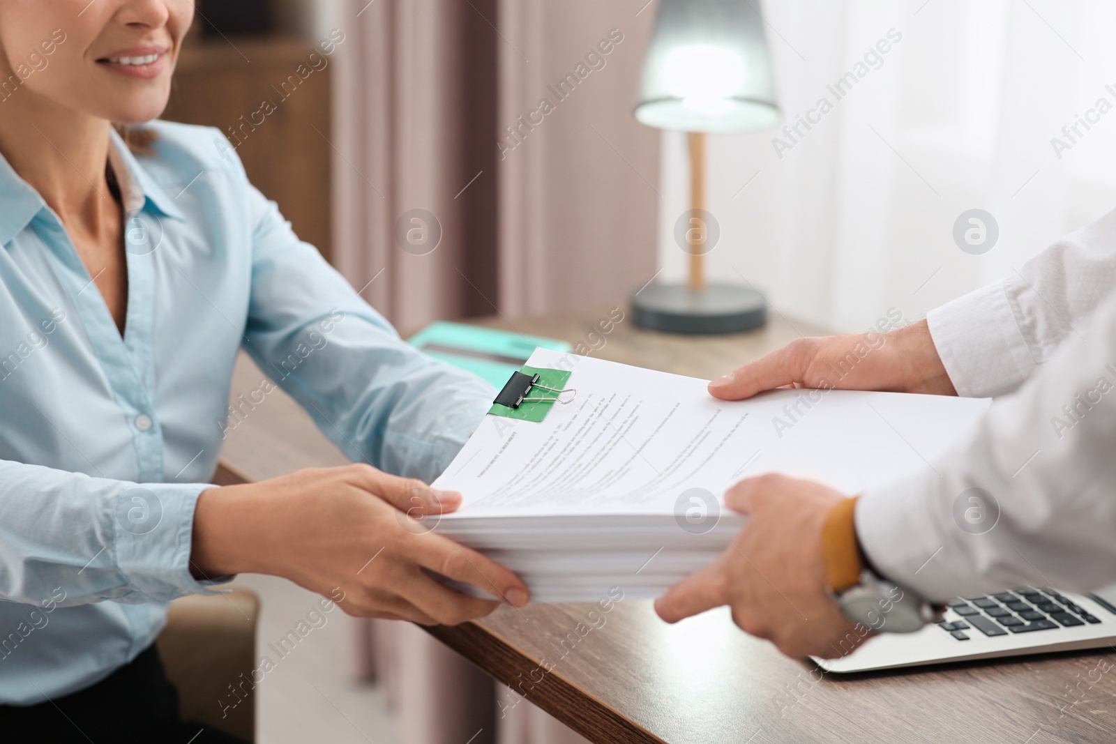 Photo of Woman giving documents to colleague in office, closeup