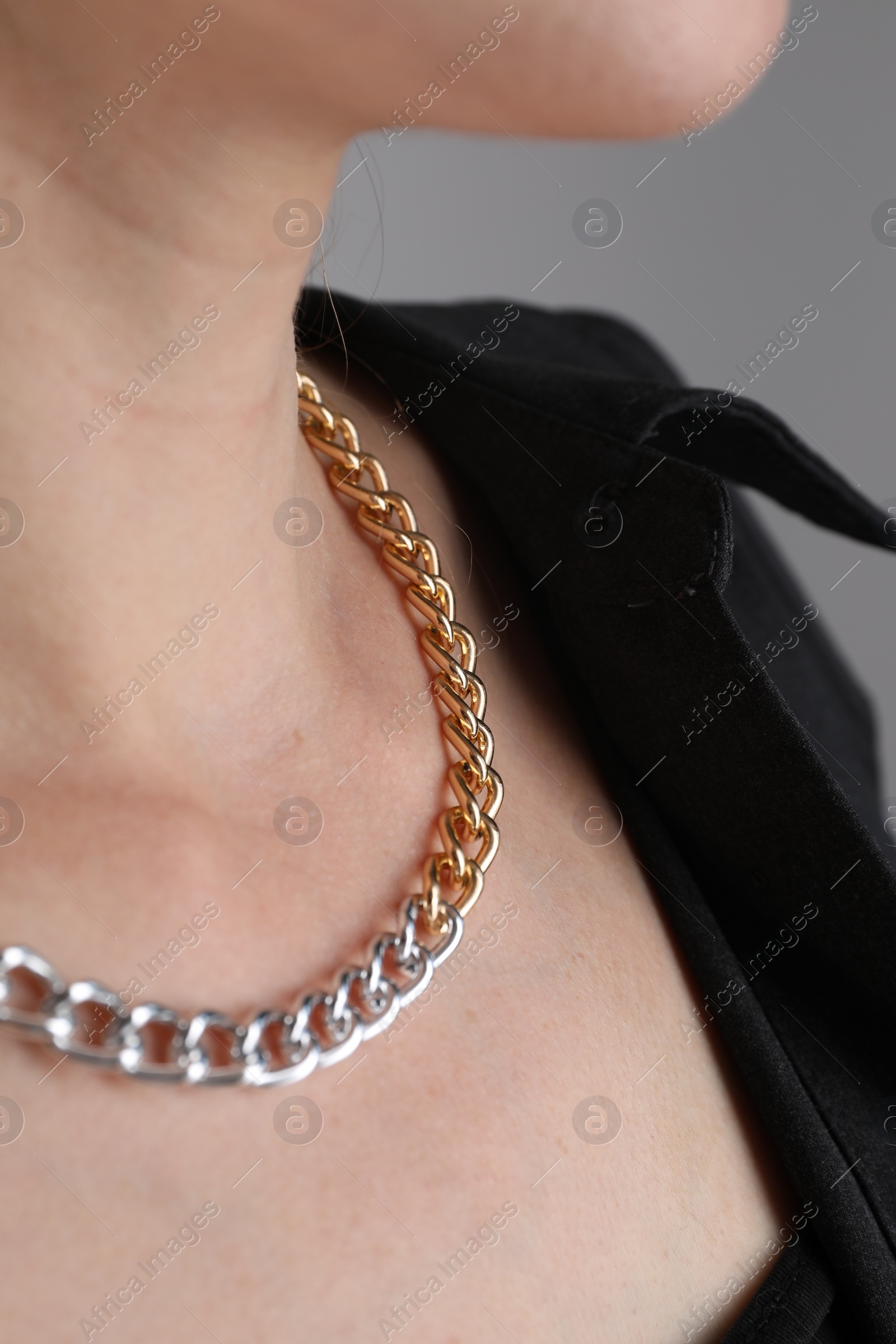 Photo of Woman wearing metal chain, closeup. Luxury jewelry