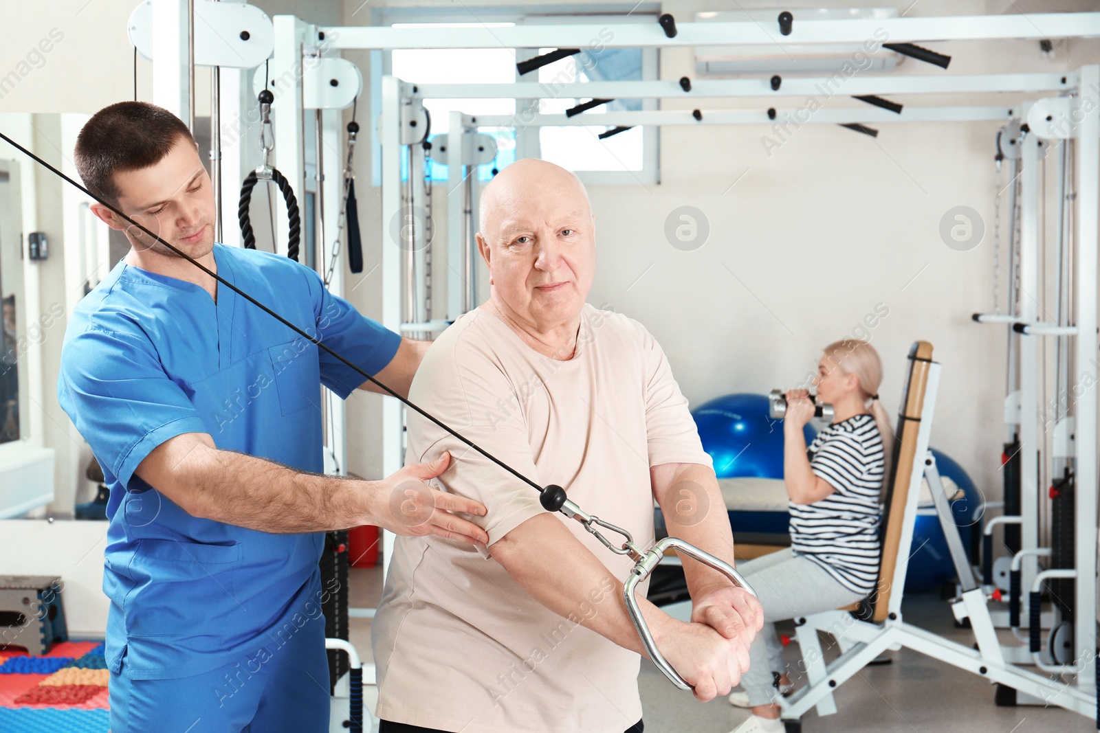 Photo of Patient exercising under physiotherapist supervision in rehabilitation center