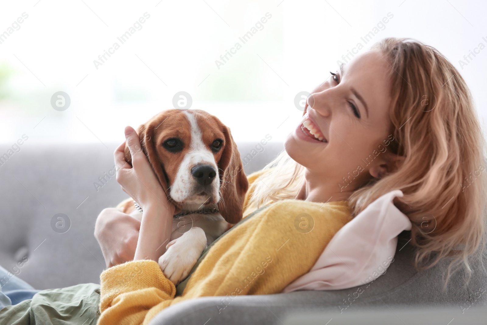 Photo of Young woman with her dog at home