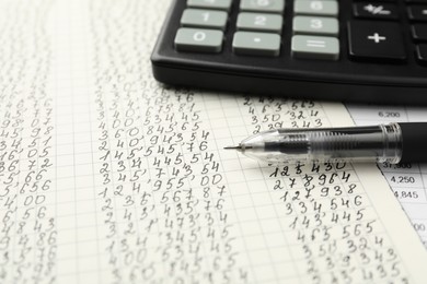Photo of Calculator and pen on documents with data, closeup