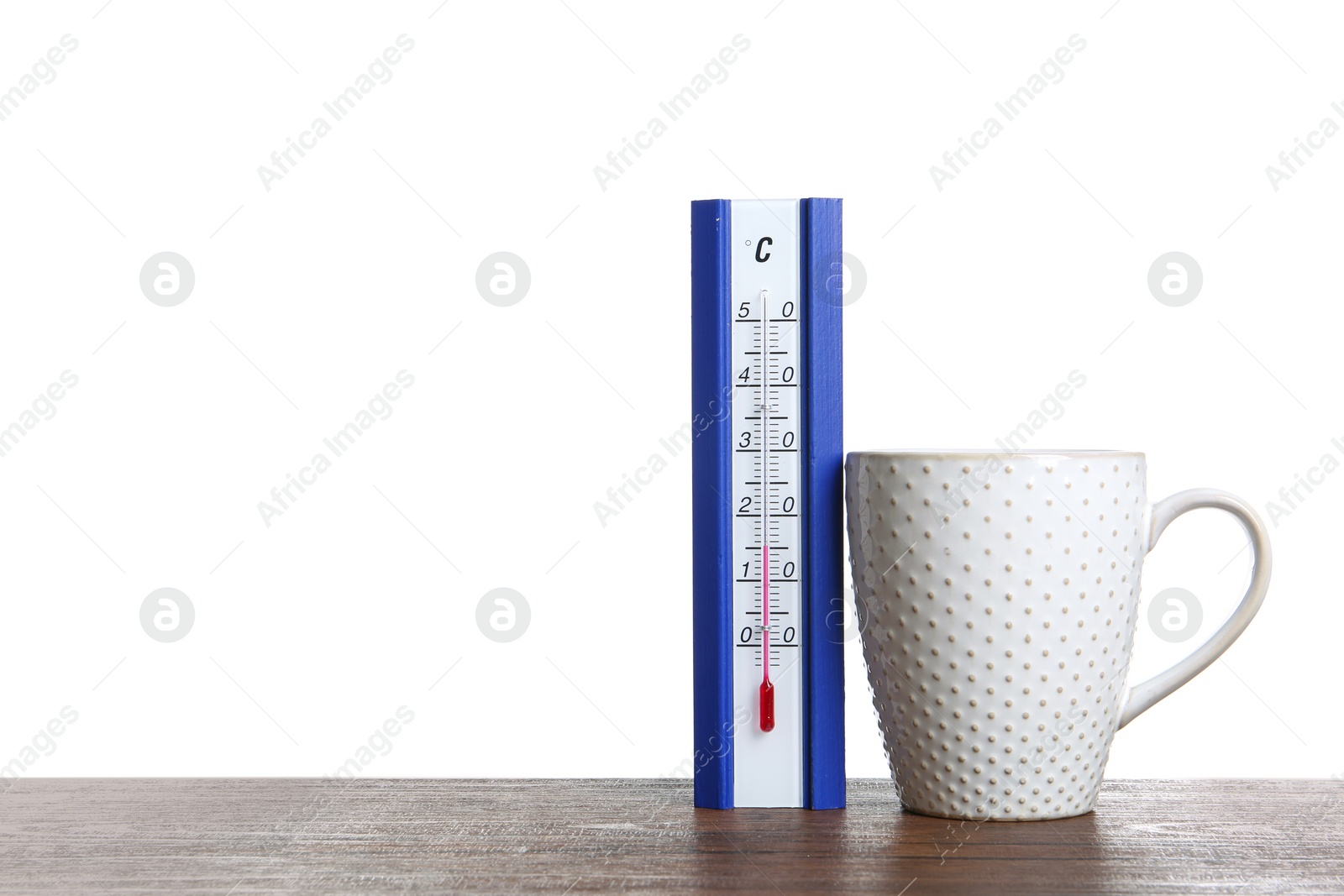 Photo of Thermometer and cup of hot tea on wooden table against white background. Space for text