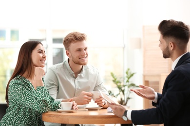 Insurance agent working with young couple in office