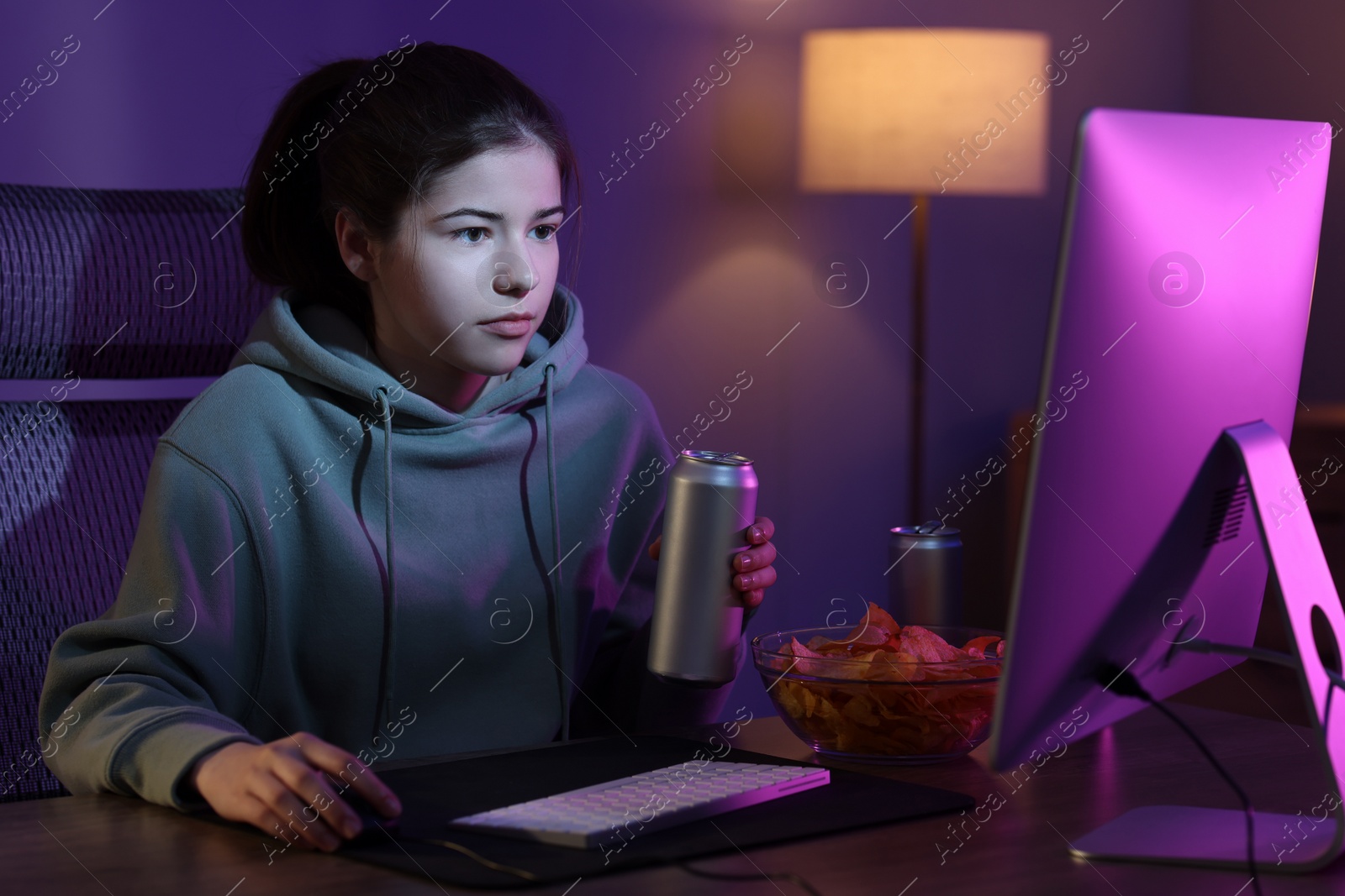 Photo of Girl with energy drink playing computer game at home