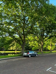 Modern car parked near lake on sunny day