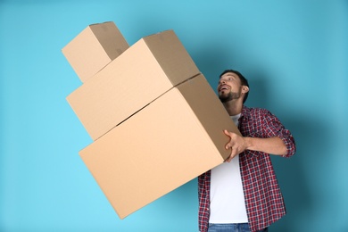 Man dropping moving boxes on color background