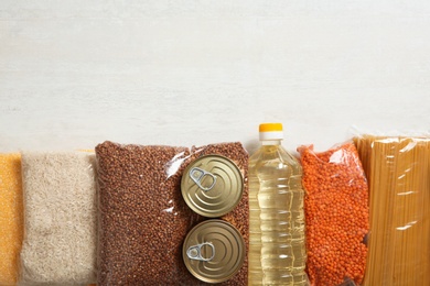 Photo of Many different products and space for text on white wooden background, flat lay. Food donation