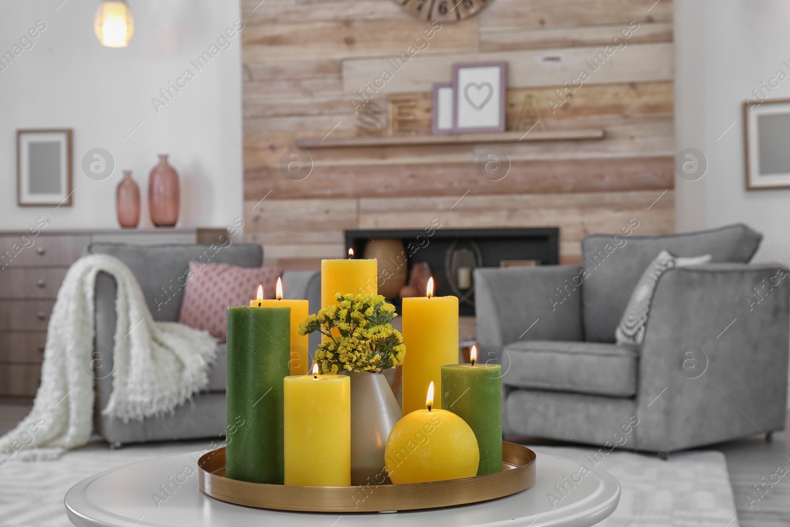 Photo of Tray with burning candles on table in living room