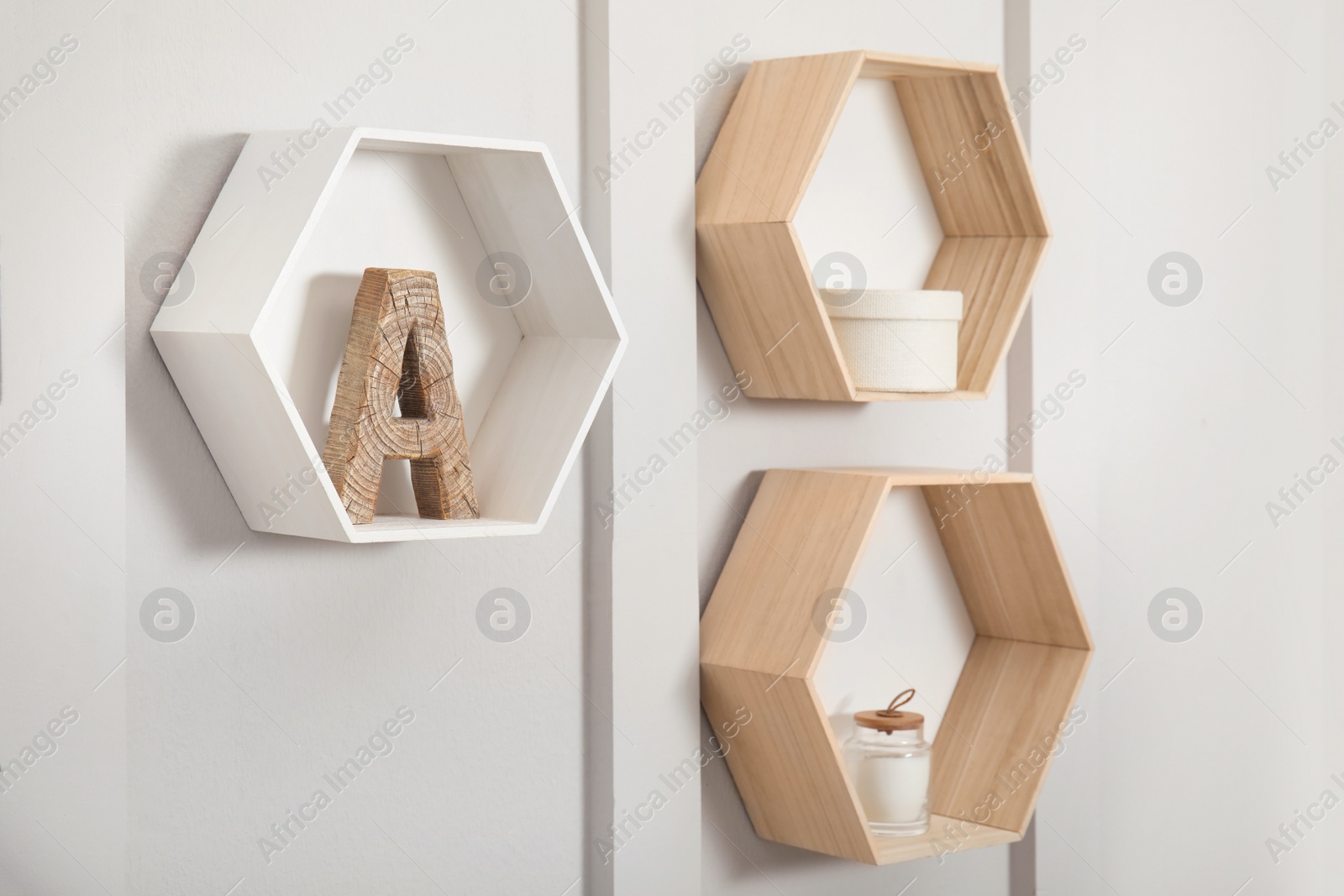 Photo of Honeycomb shaped shelves with decorative elements on white wall