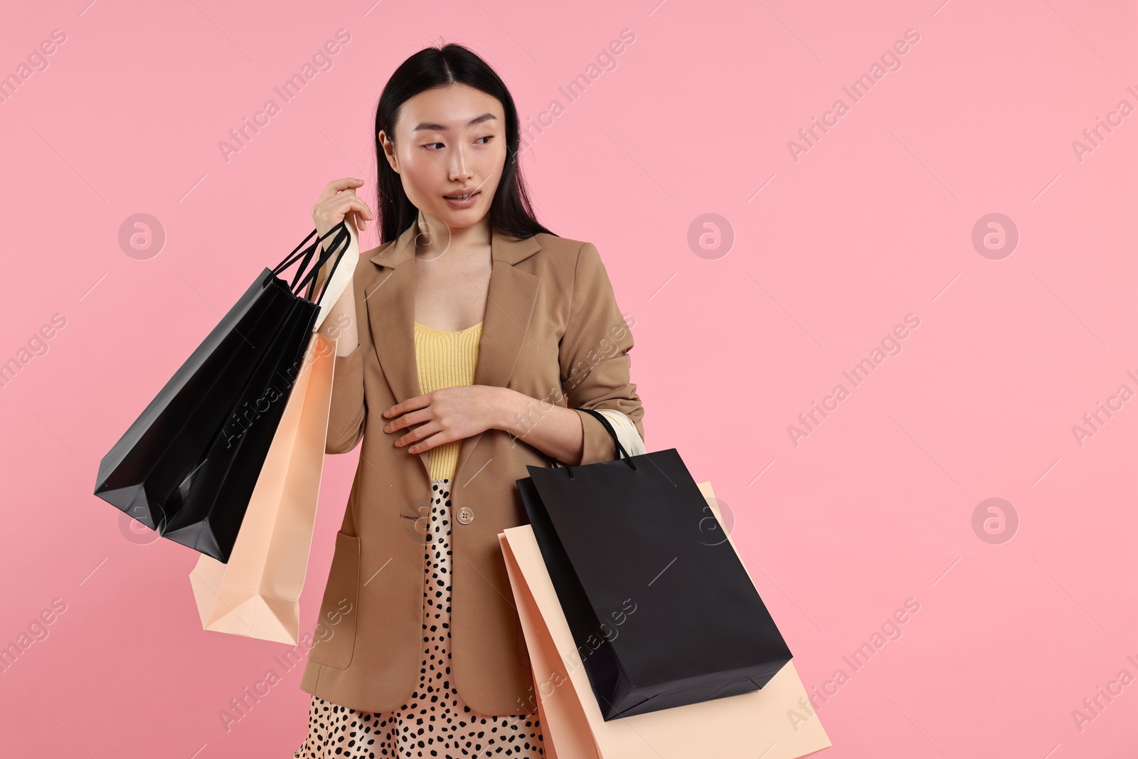 Photo of Beautiful woman with shopping bags on pink background. Space for text