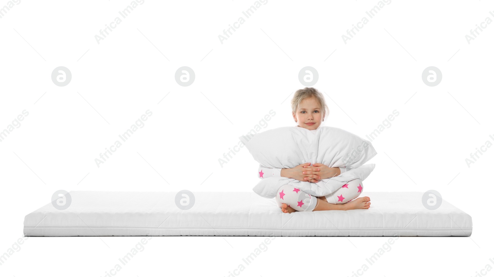 Photo of Little girl hugging pillow on mattress against white background