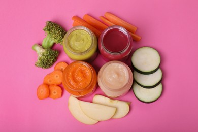 Glass jars with healthy baby food and ingredients on pink background, flat lay