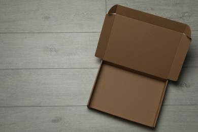 Empty open cardboard box on floor, top view. Space for text