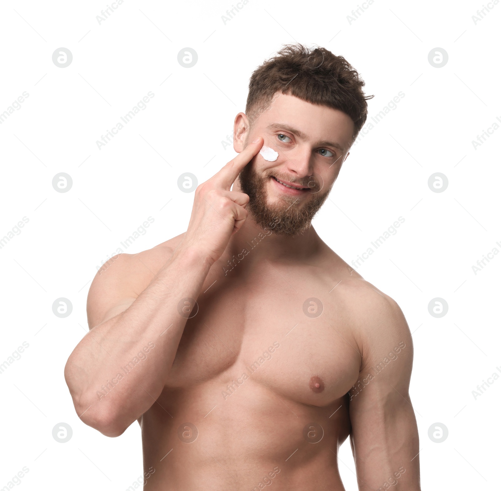 Photo of Handsome man applying moisturizing cream onto his face on white background