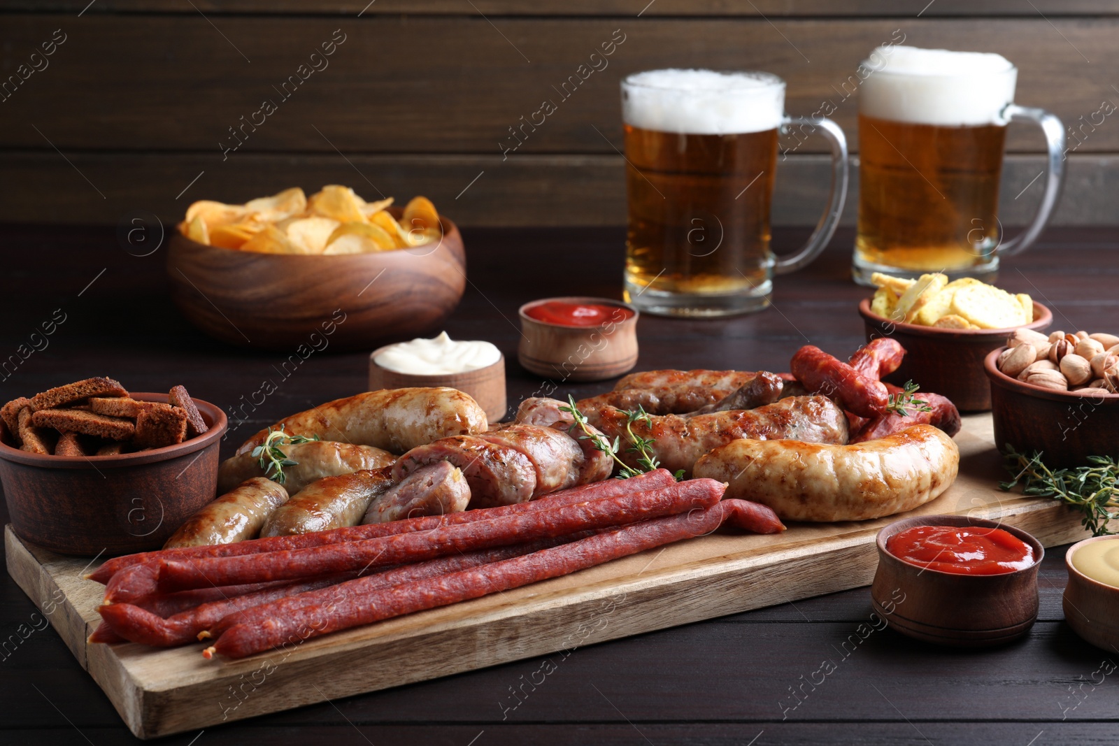 Photo of Set of different tasty snacks and beer on wooden table