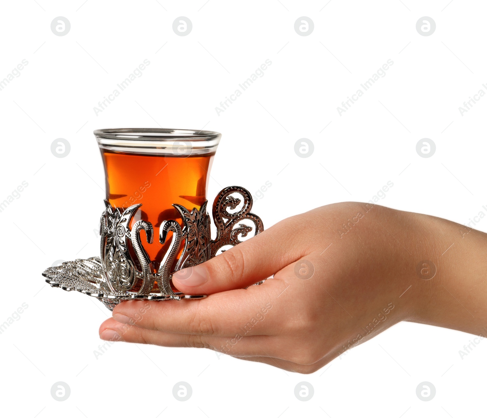 Photo of Woman holding glass of traditional Turkish tea in vintage holder on white background, closeup