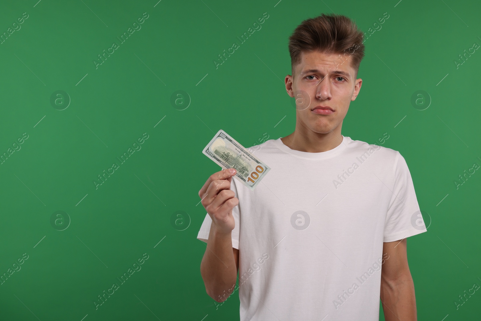 Photo of Upset man with dollar banknote on green background. Space for text