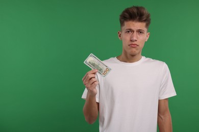 Photo of Upset man with dollar banknote on green background. Space for text