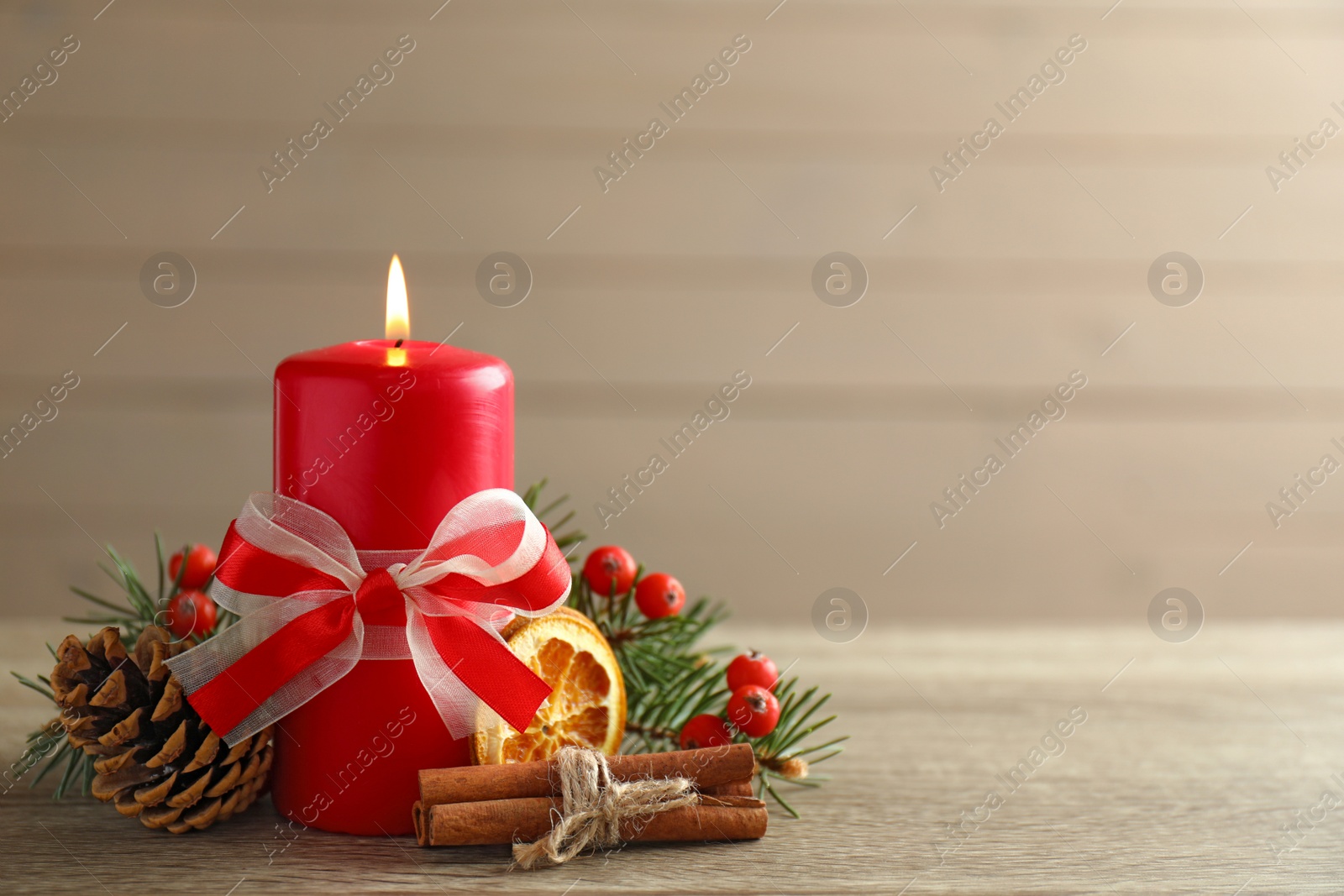 Photo of Beautiful composition with candle and Christmas decor on wooden table. Space for text