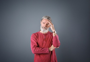 Portrait of handsome mature man on color background