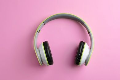 Photo of Wireless headphones on color background, top view