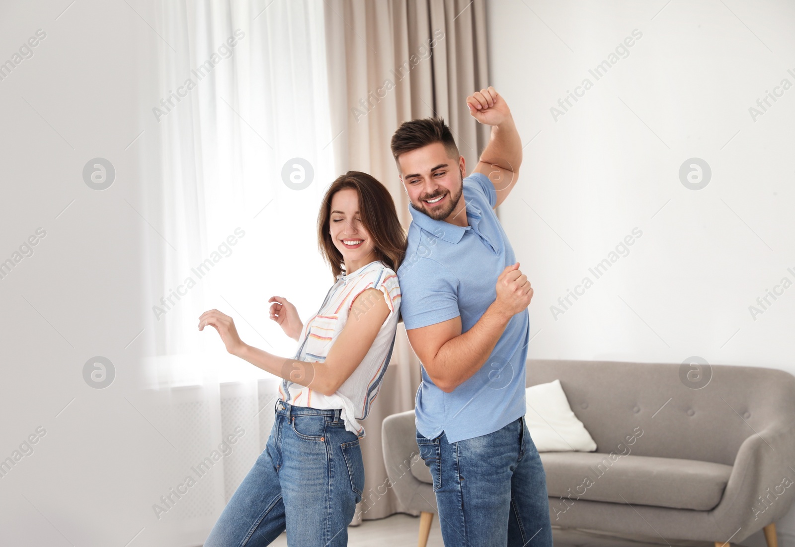 Photo of Lovely young couple dancing together at home