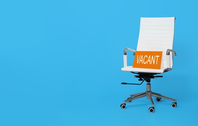 White office chair with sign VACANT on light blue background, space for text