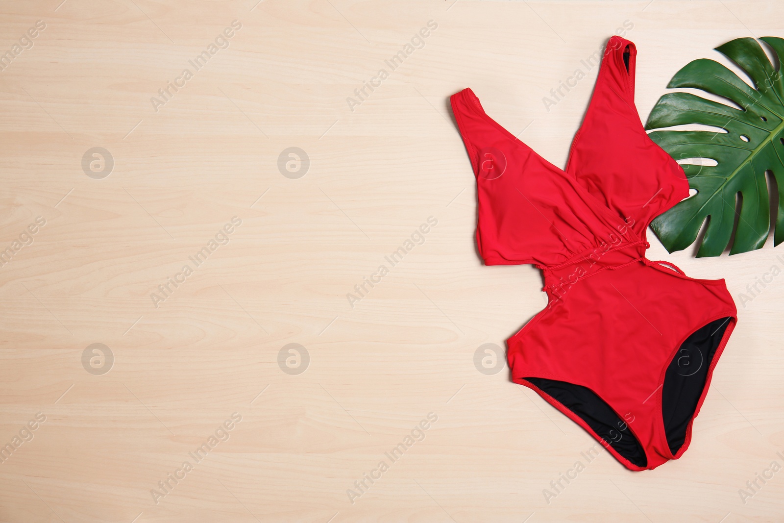 Photo of Beautiful swimsuit on wooden background, top view