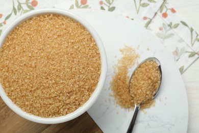 Photo of Brown sugar in bowl and spoon on table, top view