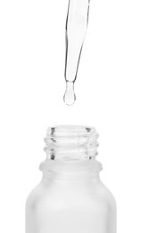 Photo of Dripping liquid from pipette into bottle isolated on white, closeup