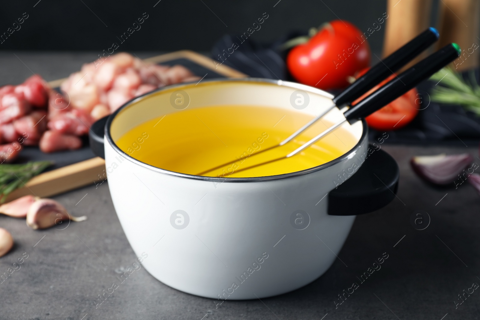 Photo of Composition with fondue pot on table against blurred background