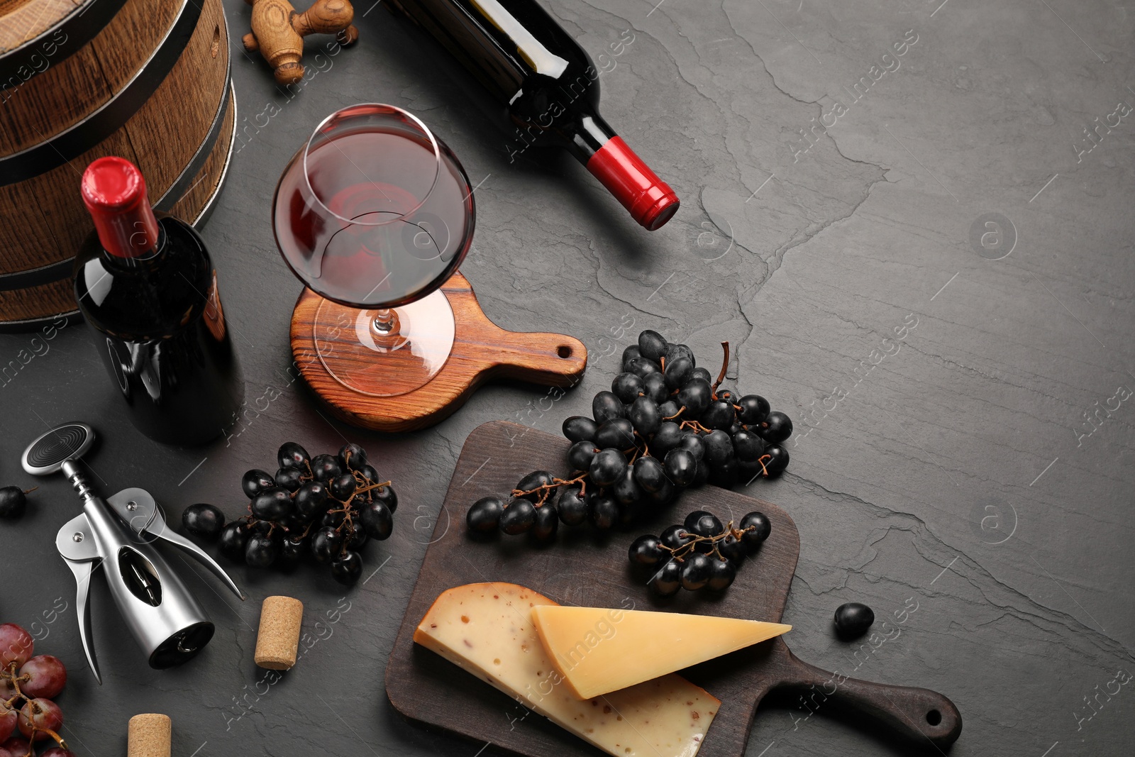 Photo of Winemaking. Composition with tasty wine and wooden barrel on gray table, above view. Space for text