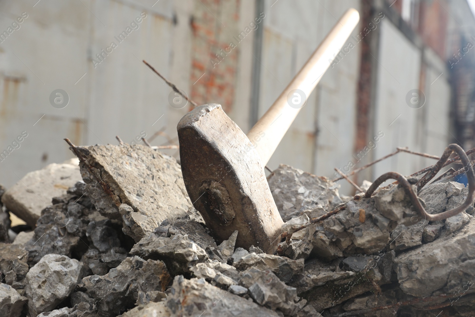 Photo of Sledgehammer on pile of broken stones outdoors, closeup