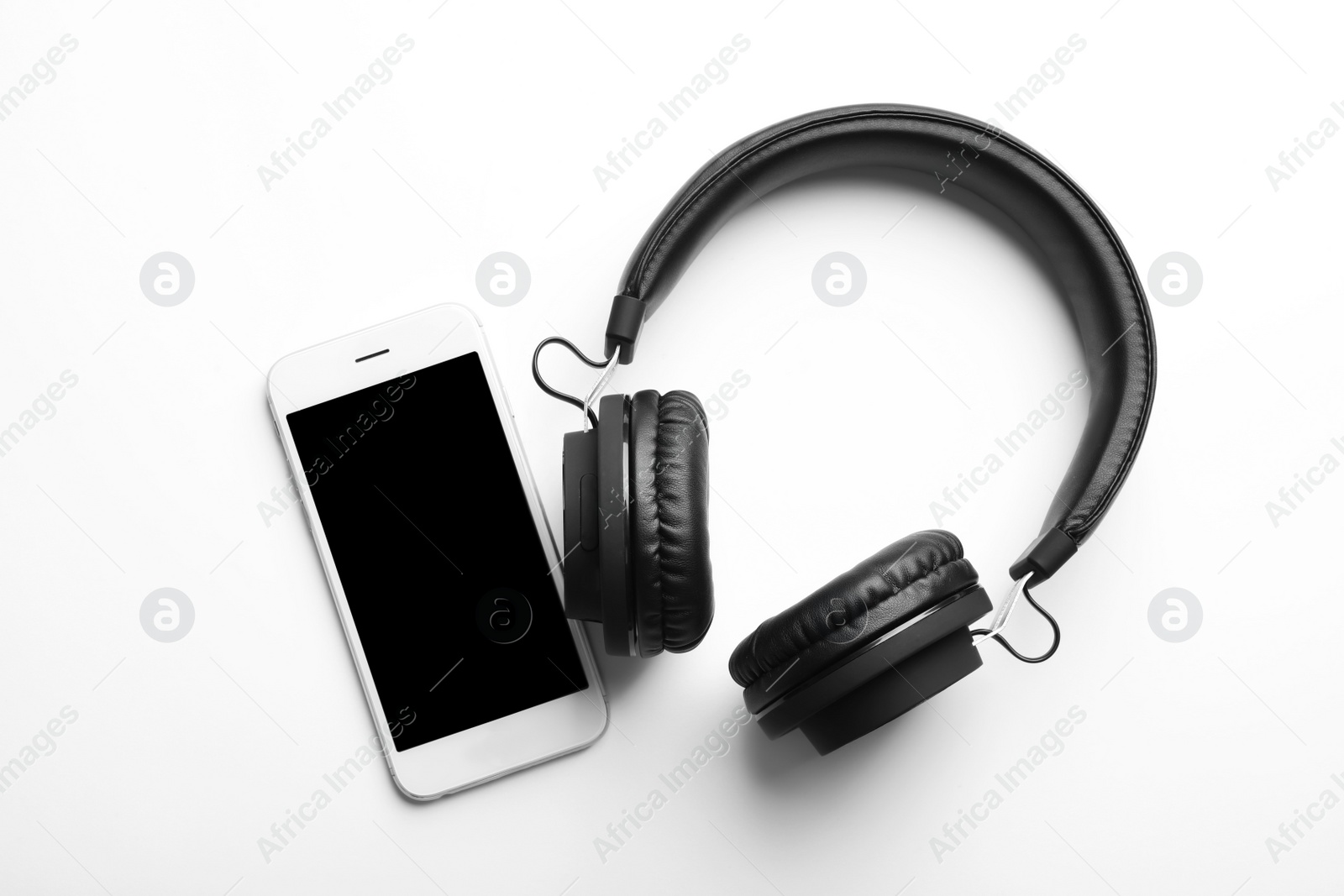 Photo of Stylish headphones and modern phone on white background, top view. Space for text