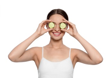 Photo of Young woman with cucumber slices on white background. Eye skin care