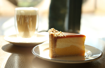 Piece of delicious cheesecake on table in cafe
