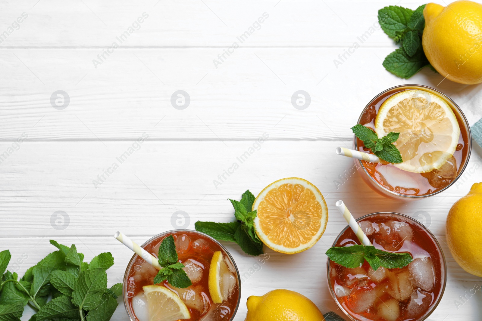 Photo of Flat lay composition with delicious iced tea on white wooden table, space for text