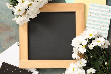 Blackboard, stationery and flowers on blue wooden table, flat lay with space for text. Teacher's Day